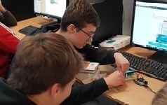 Uczniowie poprawiający układ elektroniczny z wyświetlaczem podłączony do Arduino
