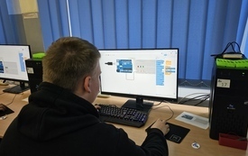 Uczeń przeglądający program bloczkowy w tinkercadzie, obok na komputerze arduino i komponenty